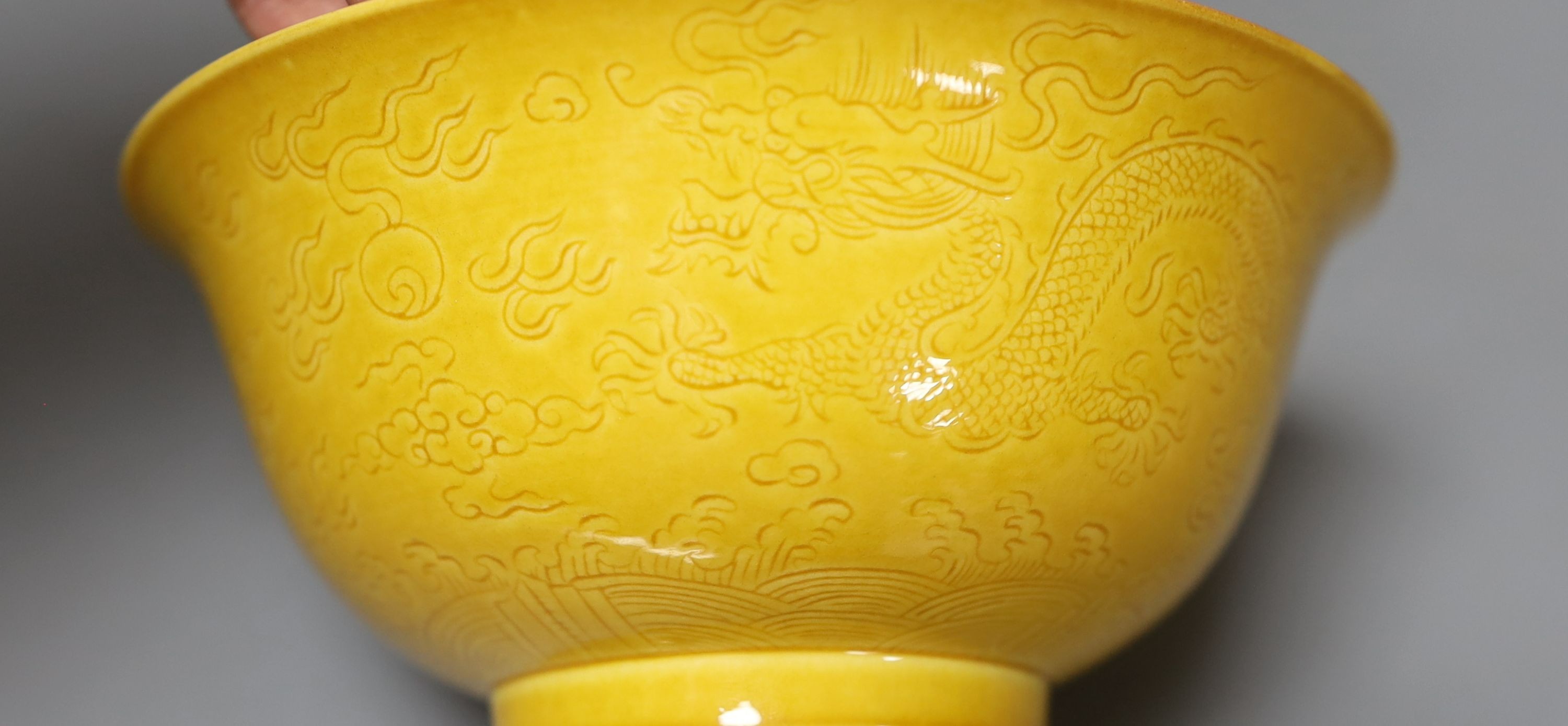 Three Chinese ceramics, including a yellow bowl with inscription to base, 7cm tall, blue and white dragon pattern candlestick mount and export dish